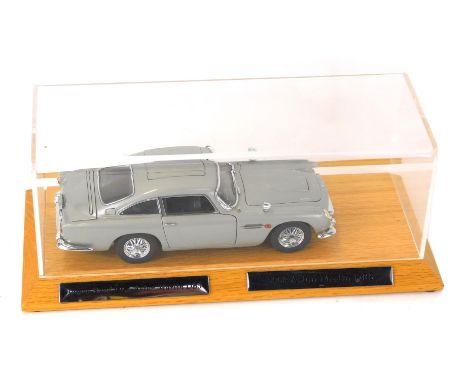 A Danbury Mint 1:25 scale model of the 1964 James Bond 007 Aston Martin DB5, serial number B4604, oak stand and Perspex cover