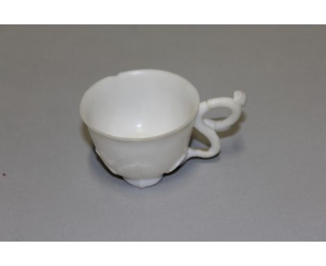 AN UNUSUAL CHINESE WHITE JADE-LIKE CUP, it's base formed with lotus leaves, it's handle with a lotus tendril, 2.3in diameter 