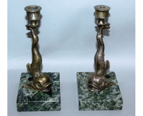 A PAIR OF BRONZE DOLPHIN CANDLESTICKS on marble bases. 7ins high.