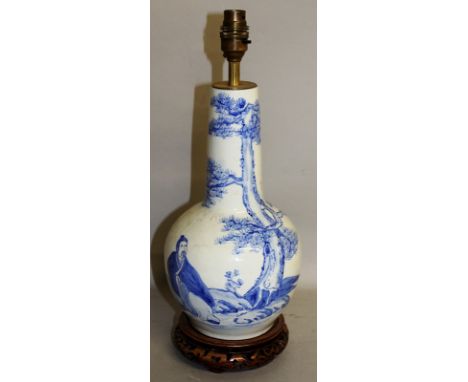 AN ORIENTAL BLUE & WHITE VASE with figures and calligraphy, converted to an electric lamp, on a pierced wooden base.  13ins h