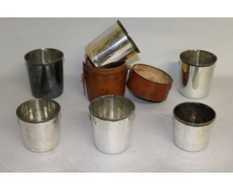 A SET OF SIX PLATED CUPS in a leather case.