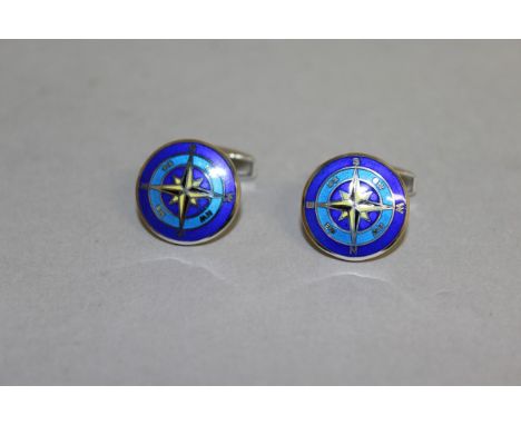 A CASED PAIR OF ENAMEL AND STERLING SILVER CUFFLINKS, in the form of a compass rose.