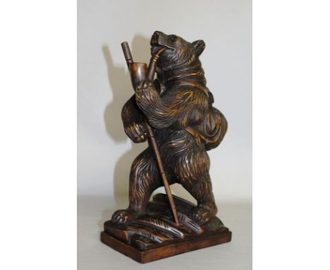 A CARVED WOOD "BLACK FOREST" BEAR smoking a pipe, a rucksack on his back. 12ins high.