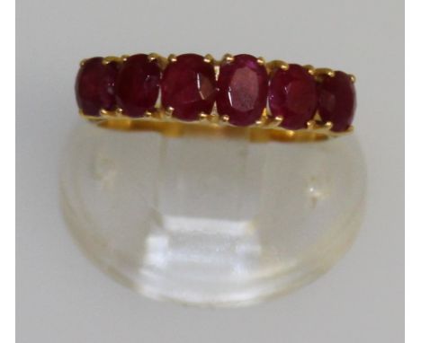 A 20K GOLD SIX STONE RUBY RING.