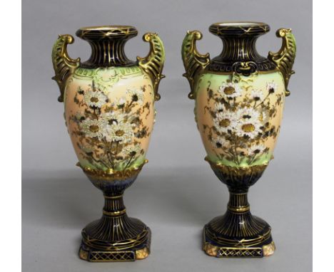 A PAIR OF GERMAN URN SHAPED TWO HANDLED VASES in The Royal Worcester style, blue and gilt ground painted with chrysanthemums.