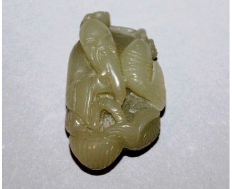 A 19TH/20TH CENTURY CHINESE CELADON JADE-LIKE PENDANT, carved in the form of a fisherman holding a carp, 2.25in high.