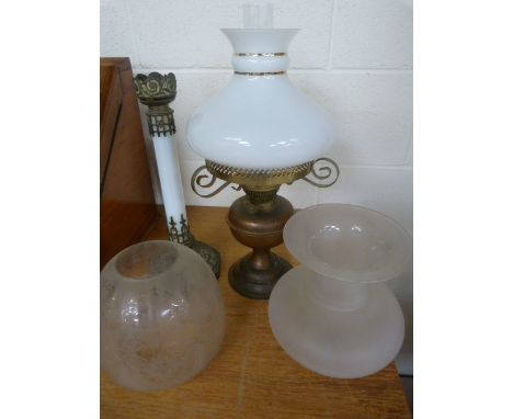 Tall gilt oil lamp with floral decoration to base, above long glass stem leading to a frosted glass bowl and one other oil la