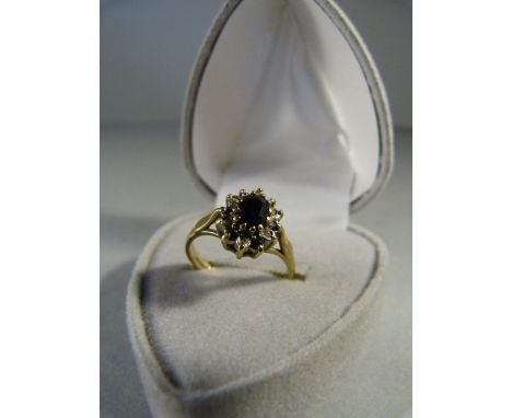 Sapphire and Diamond cluster ring set in 9ct Gold. Oval Approx 5.80mm x 4.1mm dark sapphire centre stone wuth six sapphire an