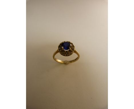 9ct gold ring set with blue sapphire stone and white stones surrounding 