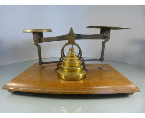 Set of Brass Postage scales sat on an oak base with full set of brass weights - To one of the scale plates reads 'Rates of Po