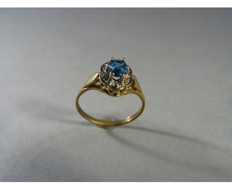 Blue Topaz and diamond cluster ring set in 9ct Gold. The oval Topaz in approx 5.26mm x 3.92mm with 4 small diamonds. UK - K -