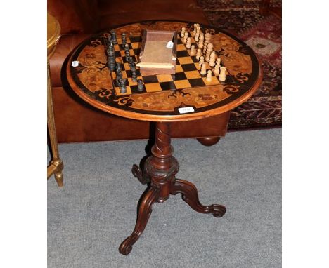 A mahogany inlaid tripod games table, together with a carved wooden chess set, with box 