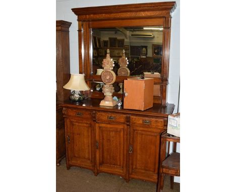 An early 20th century oak mirror backed sideboard with Art Nouveau stylised handles, 230cm high by 145cm wide 