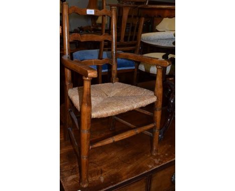 A child's rush seated ladder back armchair, 68cm high 
