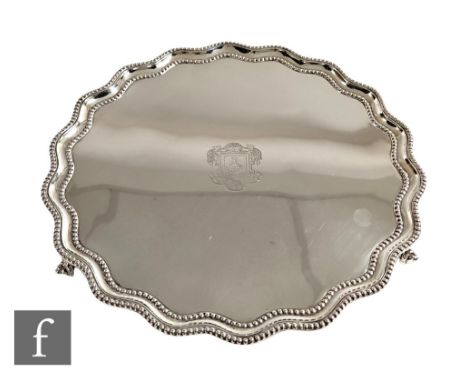 A hallmarked silver circular salver with central engraved crest and beaded decorated borders, weight 29oz, diameter 30cm, rai