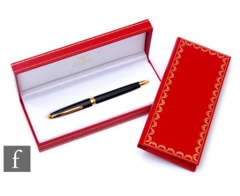 A Must De Cartier black lacquer rollerball pen complete with inner and outer boxes, instruction and guarantee leaflet dated 1