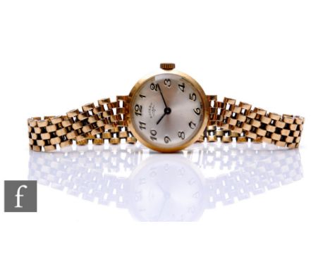 A lady's 9ct hallmarked Rotary manual wind wrist watch, Arabic numerals to a silvered circular dial to a 9ct brick bracelet, 