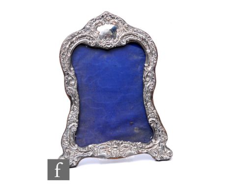 An Edwardian hallmarked silver fronted easel photograph frame with embossed floral and foliate scroll decoration to whole, he