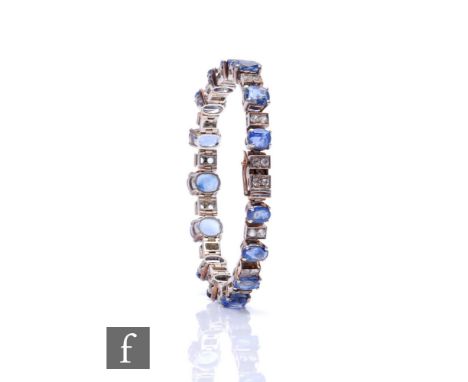 A silver sapphire and paste flexible bracelet, fifteen claw set sapphires spaced by pairs of paste stones, weight 31g, length