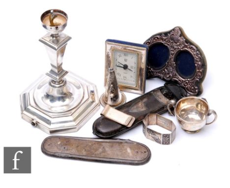 A small parcel lot of assorted silver times to include a double photograph frame, a silver mounted quartz clock, a candlestic