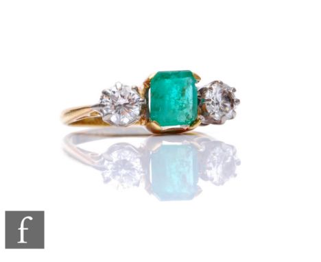 An 18ct emerald and diamond three stone ring, square cut claw set emerald flanked by a 0.40ct diamond to either side, weight 