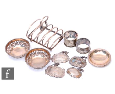 A small parcel lot of assorted silver items to include two bon bon dishes, napkin rings, decanter labels, a toast rack etc, t