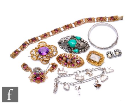 A small parcel lot of assorted silver and costume jewellery to include a silver charm bracelet, a memorial brooch etc. 