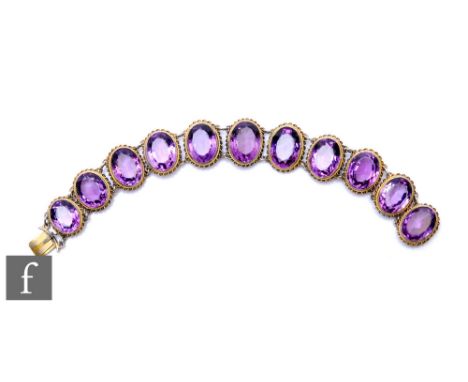 An early 20th Century silver amethyst set bracelet, comprising eleven oval cut collar set stones united by jump rings, weight