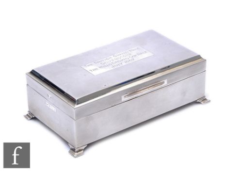 A hallmarked silver rectangular cigarette box with engine turned decoration and a presentation plaque 'The British Grand Prix