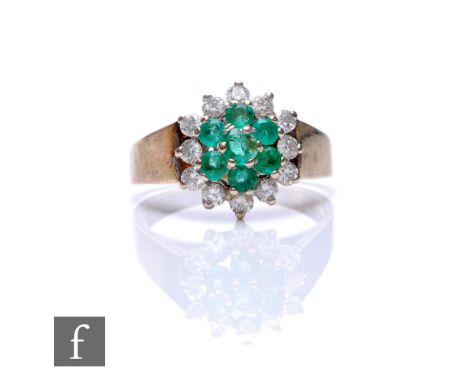 An 18ct hallmarked emerald and diamond cluster ring, central seven stone emerald cluster within a border of twelve brilliant 