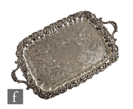 A William IV hallmarked silver twin handled tray with central presentation engraving within engraved foliate decoration and r