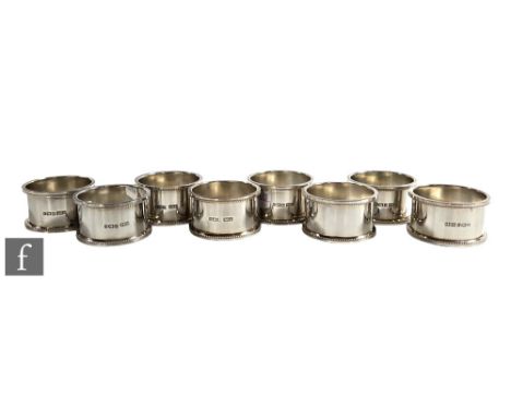 A set of eight hallmarked silver circular napkin rings of plain form terminating in beaded borders, total weight 5.8oz, Birmi