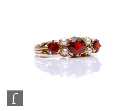 A 9ct hallmarked garnet and seed pearl ring, three garnets spaced by pearls, weight 3.4g, ring size Q 1/2. 