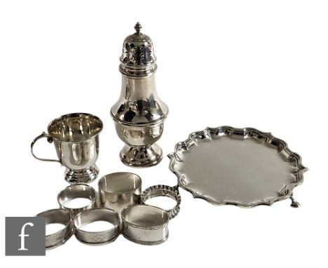 A small parcel lot of assorted hallmarked silver to include a card waiter, a sugar castor, seven napkin rings and a small cup