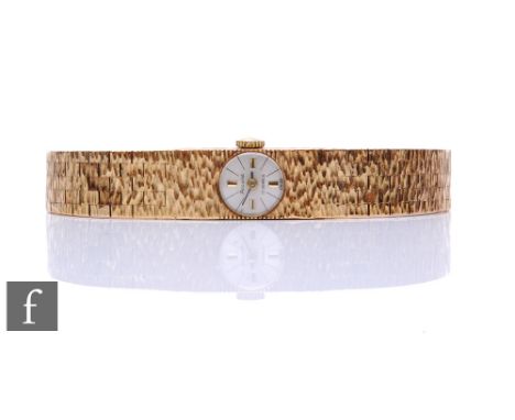 A 9ct hallmarked lady's manual wind Accurist wrist watch, batons to a silvered rectangular dial to an integral brick bracelet