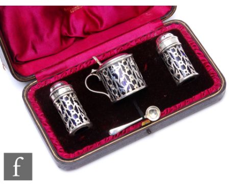 A cased hallmarked silver three piece cruet set with pierced cylindrical bodies and blue glass liners, weight 2.5oz, Edinburg