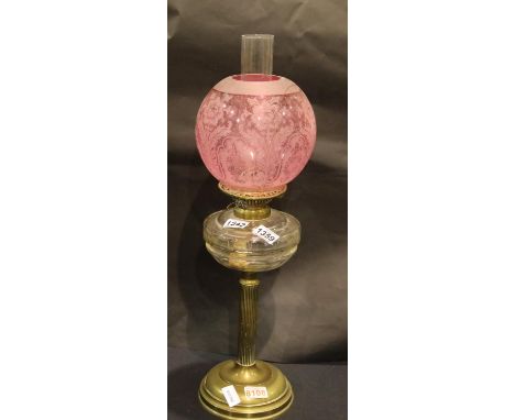 Victorian brass columnar oil lamp with Cranberry glass shade, H: 90 cm. Not available for in-house P&P, contact Paul O'Hea at