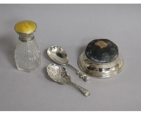 A George V silver mounted pin cushion, two Victorian silver caddy spoons and a silver and enamel topped scent bottle.