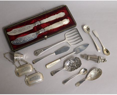 A cased pair of Victorian silver butter knives and twelve other silver items including, wine labels, whistle, caddy spoons an