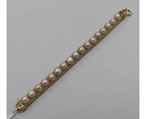 A yellow metal and split pearl set cagework line bracelet. 17.5cm.