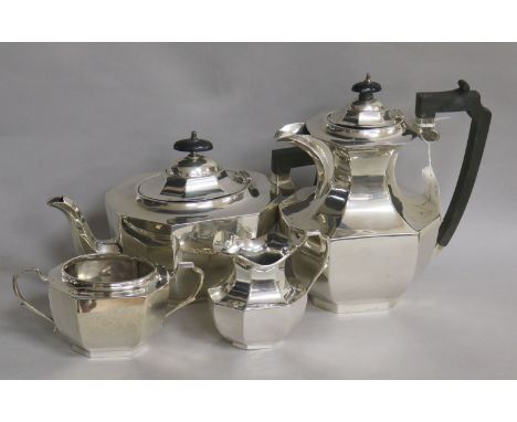 A silver matched four-piece tea service, of oval octagonal baluster form, comprising teapot and hot water pot with ebonised h