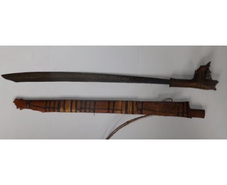 An antique head hunter's Dyak sword in wooden scabbard, 34” overall