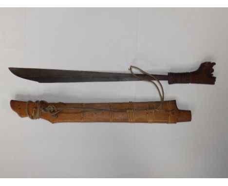 An antique head hunters Dyak sword in wooden scabbard