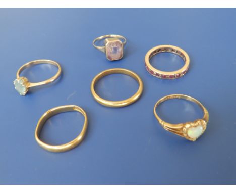 An eternity ring set with ruby coloured stones, a heart shaped cluster ring, two gem set rings and two 22 carat wedding bands