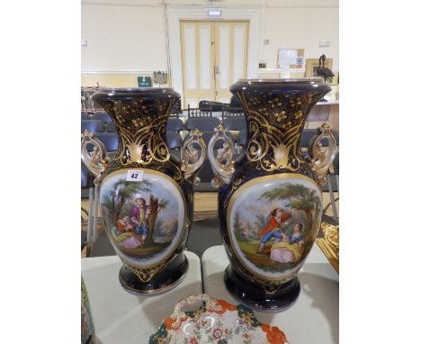 A large pair of 19thC continental porcelain two=handled vases, each decorated with an oval panel depicting a courting couple 