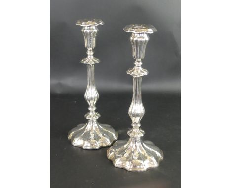 A pair of Victorian silver candlesticksOf fluted knopped form, engraved with scroll and foliate detail, raised on a shaped ci