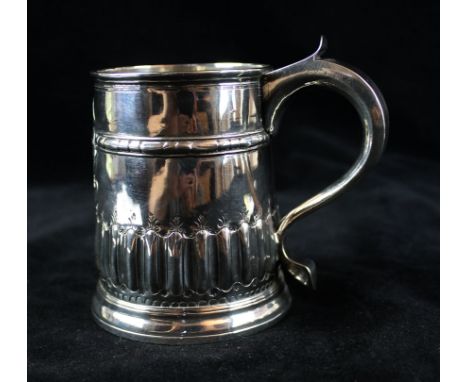 A George I English provincial silver half pint mugOf tapered cylindrical form, with an embossed band and a fluted lower body,