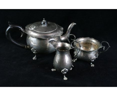 A silver matched bachelor's three piece tea serviceOf circular form, with wavy edges, raised on four claw feet, comprising; a