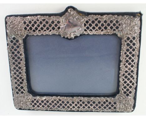 A modern silver photograph frameOf rectangular form, with pierced lattice and scroll decoration, to a blue velvet ground, vac