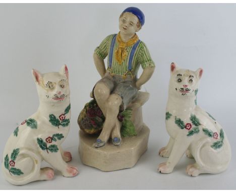 An 18th/19th Century pearl ware figureModelled in the form of a boy seated with a basket of fruit at his feet, height 23cm, t